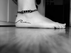 a black and white photo of a person's foot with a tattoo on it