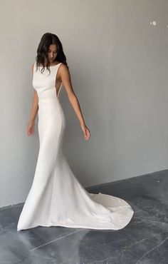 a woman in a white wedding dress standing next to a wall