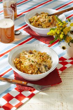 two white bowls filled with food sitting on top of a red and blue table cloth