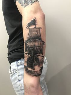 a man's arm with a ship tattoo on it