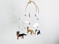 a mobile with dogs hanging from it's sides and clouds above the animals on them