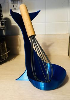 a whisk is sitting on top of a blue stand