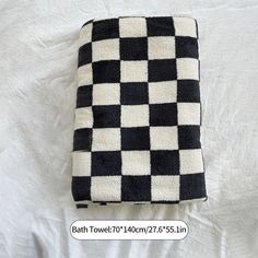 a black and white checkered towel laying on top of a bed