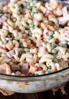 a bowl filled with pasta and peas on top of a wooden table