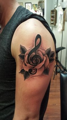 a man with a rose and treble tattoo on his arm