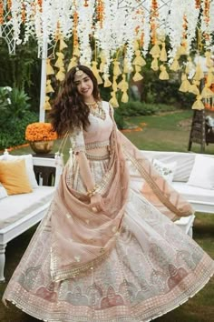 a woman in a white and pink lehenga