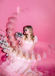 a woman in a white dress blowing bubbles