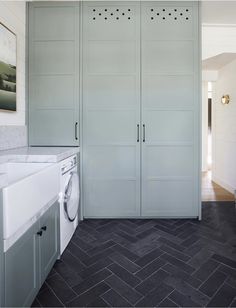 a washer and dryer sitting in a room next to a wall mounted cabinet