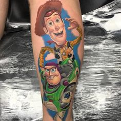 a man with a tattoo on his leg that has toy story characters painted on it