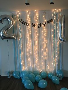 balloons and streamers in front of a backdrop with the number two on it for a new year's eve party