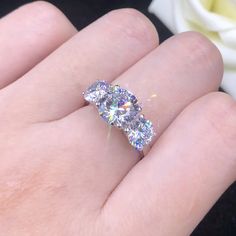 a person's hand with a diamond ring on it