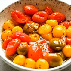 a white bowl filled with tomatoes and peppers