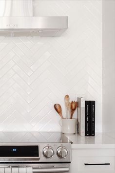 a stove top oven sitting inside of a kitchen next to a wall mounted range hood