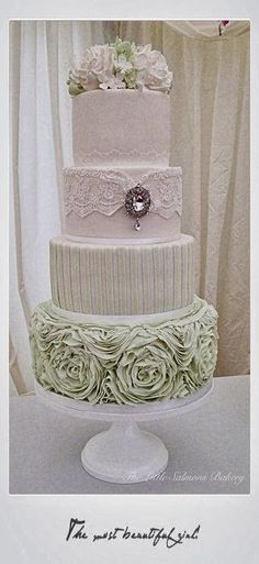 a three tiered cake with white flowers on top