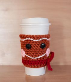 What says the holiday season like a gingerbread man cup cozy? I can almost smell the spicy goodness, fresh from the oven! This little fella is ginger brown with a sugary sweet icing smile, pink cheeks, button eyes and a jaunty red scarf. Someone on your Christmas list would adore this in their stocking. He will keep your fingers from burning while you drink that java.  About 4" tall and slightly flared to fit most take-out coffee cups or travel mugs. Crocheting Christmas, Cookie Crochet, Wine Cozy, Twinkie Chan, Gingerbread Coffee, Cup Cozy Pattern, Coffee Cozies