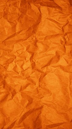 an orange crumpled paper background textured with some sort of crinkle pattern on it