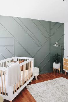 a baby's room with a crib, dresser and rug on the floor