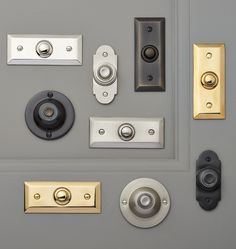 several different types of door knobs and handles on a gray door with gold trim