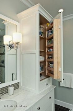 an open cabinet in the middle of a bathroom