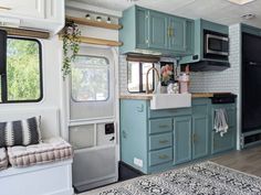 a kitchen area with blue cabinets and white tile on the walls, along with a rug