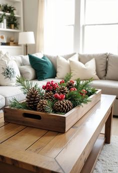 a wooden tray filled with pine cones on top of a table next to a couch