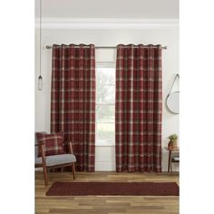 a living room with red plaid curtains and a chair