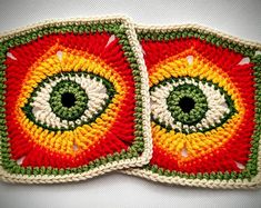 two crocheted coasters made to look like eyeballs in red, yellow and green