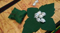 a green leaf with some silver foil wrapped around it on top of a wooden table