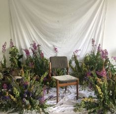 a chair sitting in front of a bunch of flowers