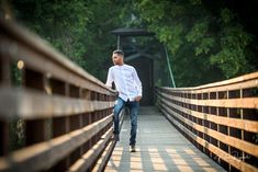 a man standing on a bridge with his skateboard