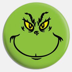 a green grin face with yellow eyes and black outline on the front of a button