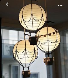 three lamps hanging from the ceiling in front of a window