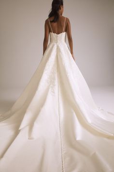 the back of a woman's wedding dress, with her hands on her hips