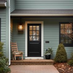 the front door of a house with steps leading up to it and a chair on the porch