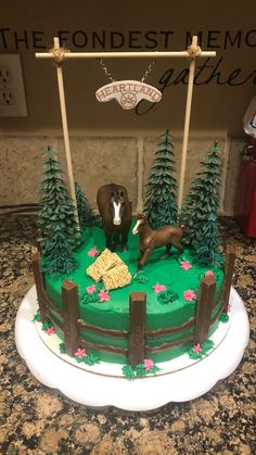 a cake decorated with horses and trees on top of a kitchen counter next to a sign that says the fondest memory gatherers