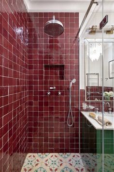 a red tiled bathroom with a shower and sink