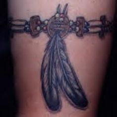 a woman's leg with a tattoo on it that has a feather and beads