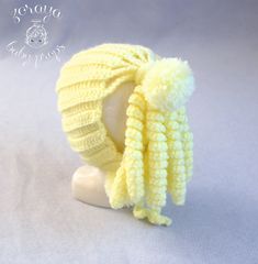 a yellow knitted hat on top of a white mannequin's head