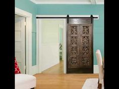 a living room filled with furniture and a wooden door in front of a blue wall