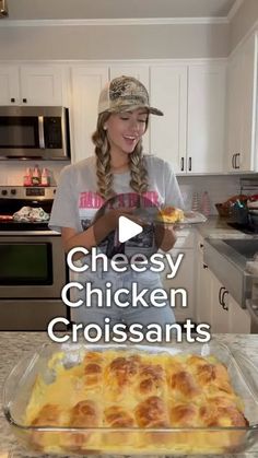 a woman standing in front of a pan filled with chicken and cheese croissants