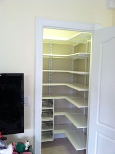 an empty room with shelves and a flat screen tv