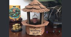 a small wooden lantern sitting on top of a table next to a potted plant