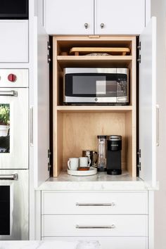 a kitchen with white cabinets and appliances in it