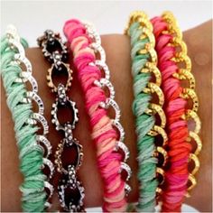 four different colored bracelets on someone's arm