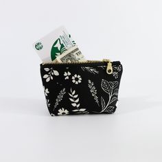 Keep your small essentials organized in style with our Black Floral Coin Pouch. This elegant pouch features a timeless black background adorned with delicate white floral patterns, making it a chic accessory for any occasion. Perfect for holding coins, keys, or other small items, this pouch is both practical and beautiful. The high-quality zipper ensures that your belongings are securely stored, while the compact size makes it easy to carry in any bag or pocket. Imagine the sophistication this p Black Zipper Coin Purse For Personal Use, Black Zipper Pouch For Gift, Black Zippered Pouch For Gifts, Black Zipper Pouch As Gift, Black Pouch With Card Slots For Gift, Black Zipper Pouch Coin Purse, Black Coin Purse With Zipper, Black Bags With Floral Print For Gifts, Elegant Pouch