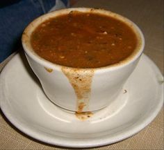 a white plate topped with a bowl of soup