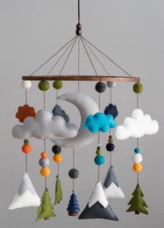 a mobile with clouds and trees hanging from it