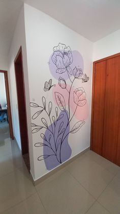 a wall with flowers painted on it next to a wooden door in an office building