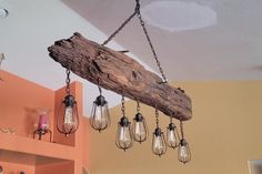 a light fixture hanging from the ceiling in a room with orange walls and wooden beams