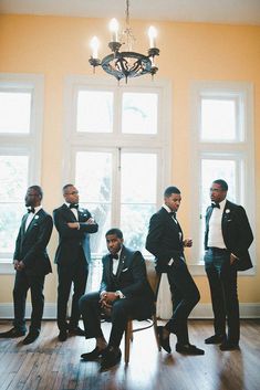 a group of men in suits standing next to each other on a hard wood floor